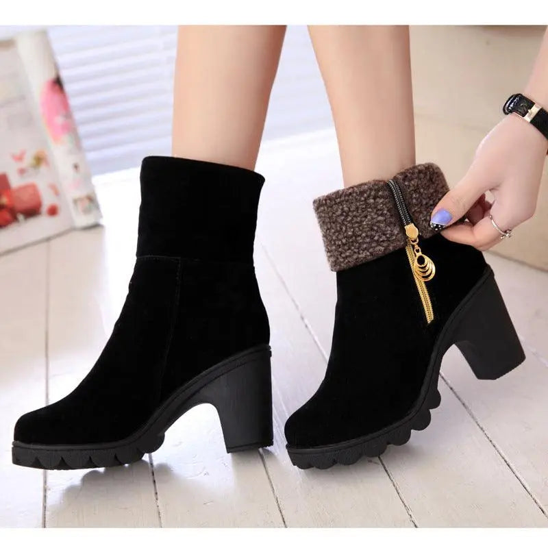 Black thick-heel snow boots with teddy cuff, gold zipper, and chunky tread sole