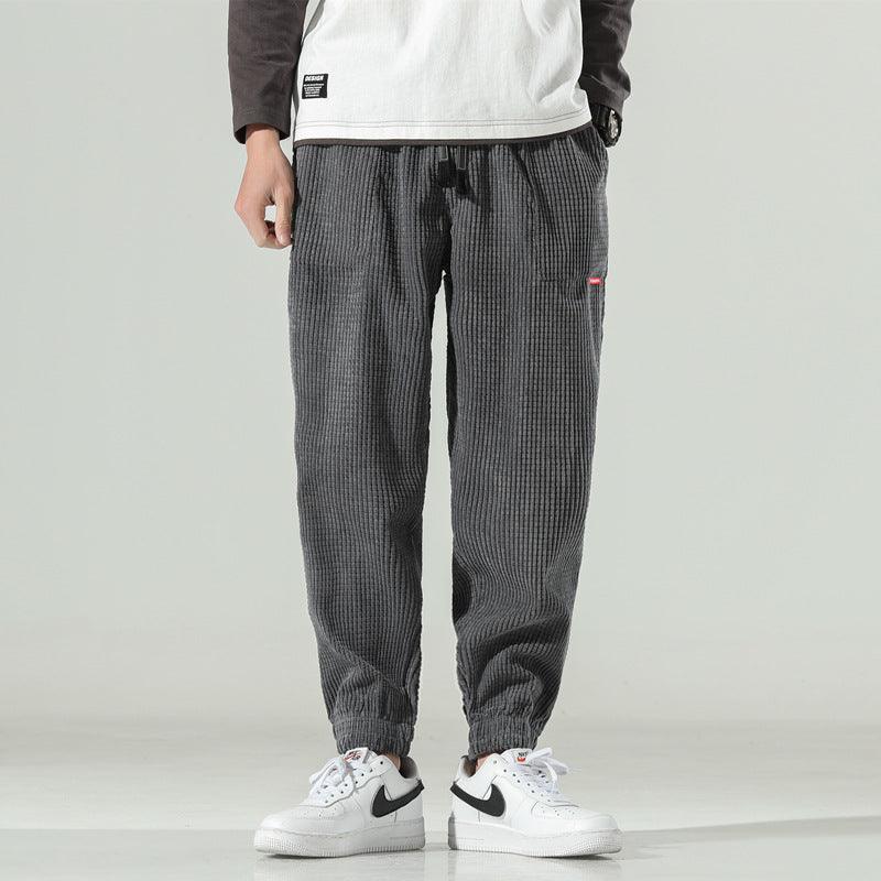 Men's dark grey corduroy jogger pants with drawstring and cuffed ankles