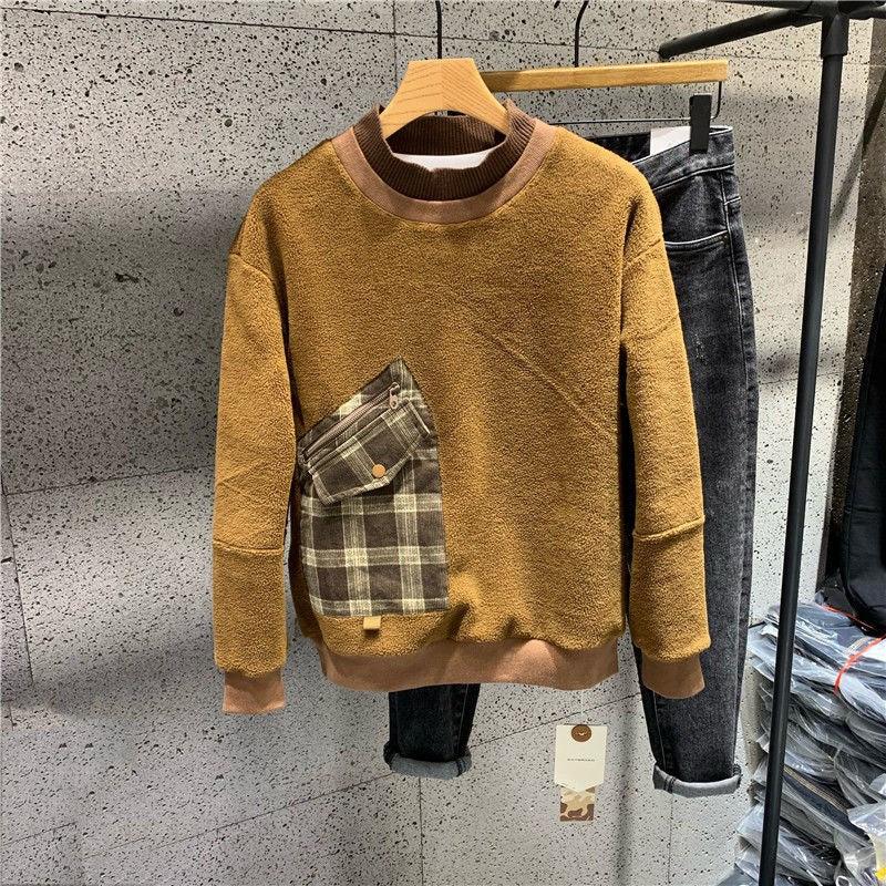 Brown crewneck sweater with long sleeves and a plaid chest pocket-style patch