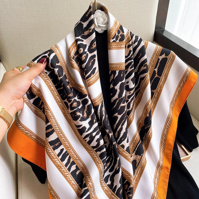 Women's silk scarf with leopard print in black and beige, gold border accents