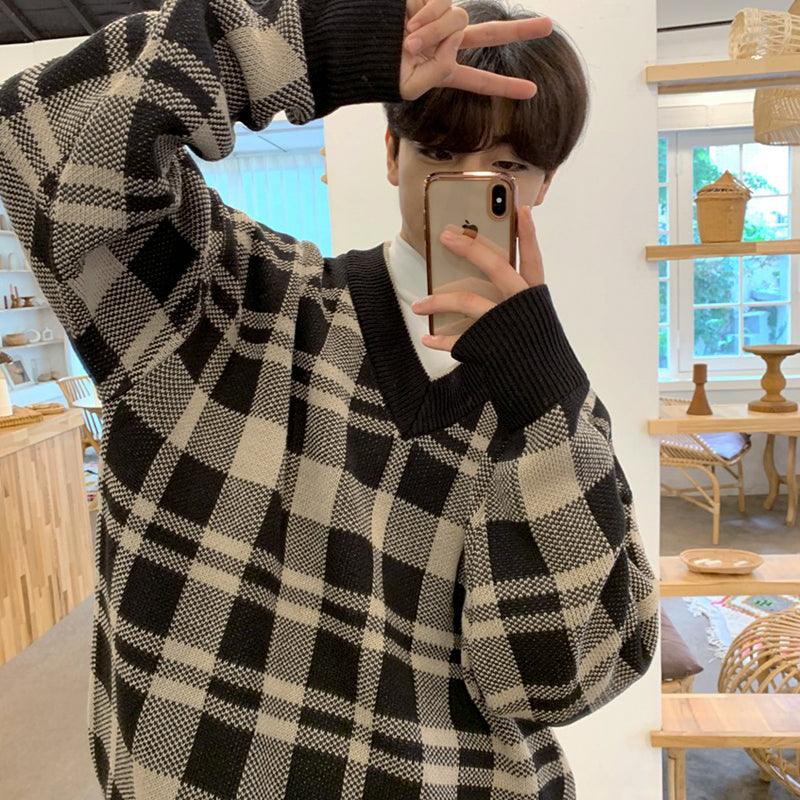 Plaid knit V-neck sweater sleeve close-up in black and cream with ribbed cuff