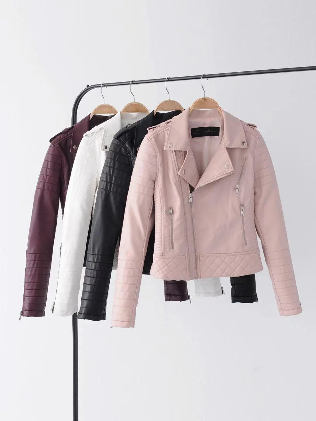 Women’s cropped jackets on hangers in pink, white, black, and burgundy colors