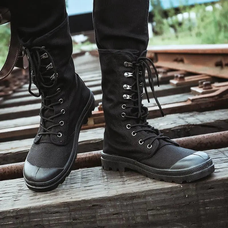 Black canvas lace-up high-top boots with metal eyelets and rugged rubber sole, angled