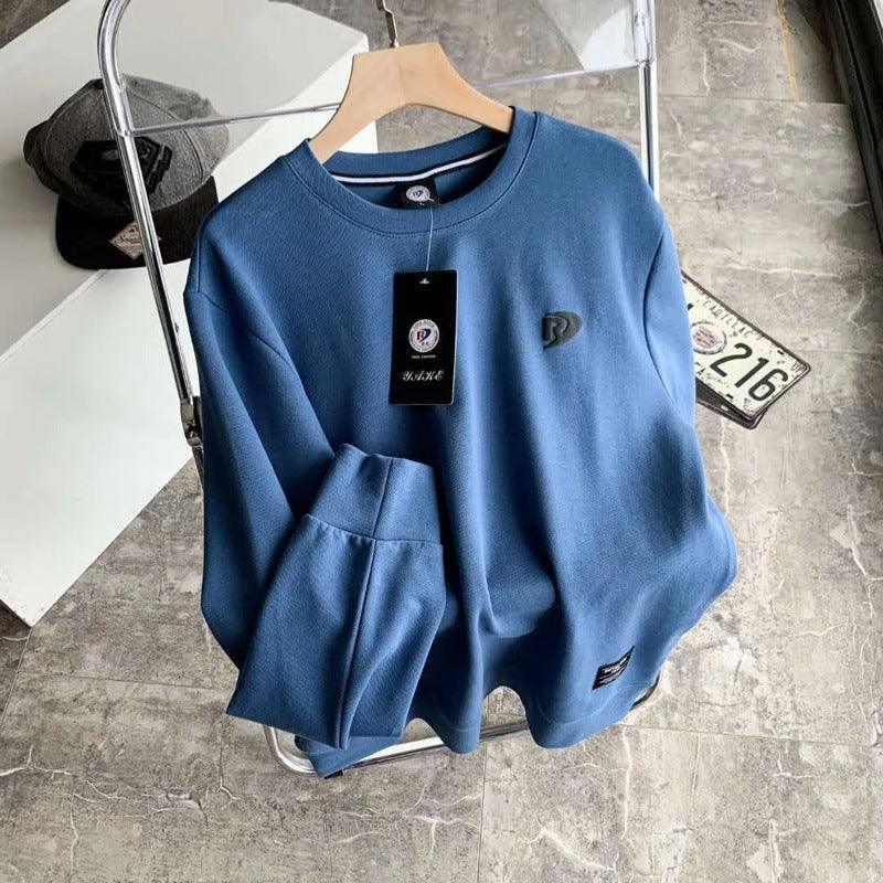 Blue long-sleeve pullover base shirt with crew neck, kangaroo pocket, and chest logo tag.