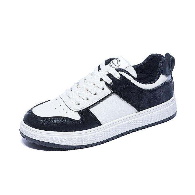 Black and white low-top lace-up sneakers, front view with padded tongue