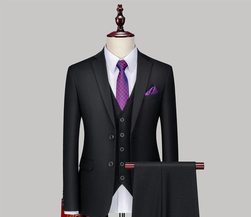 Three-piece suit set in dark fabric with waistcoat, patterned tie, pocket square, and trousers