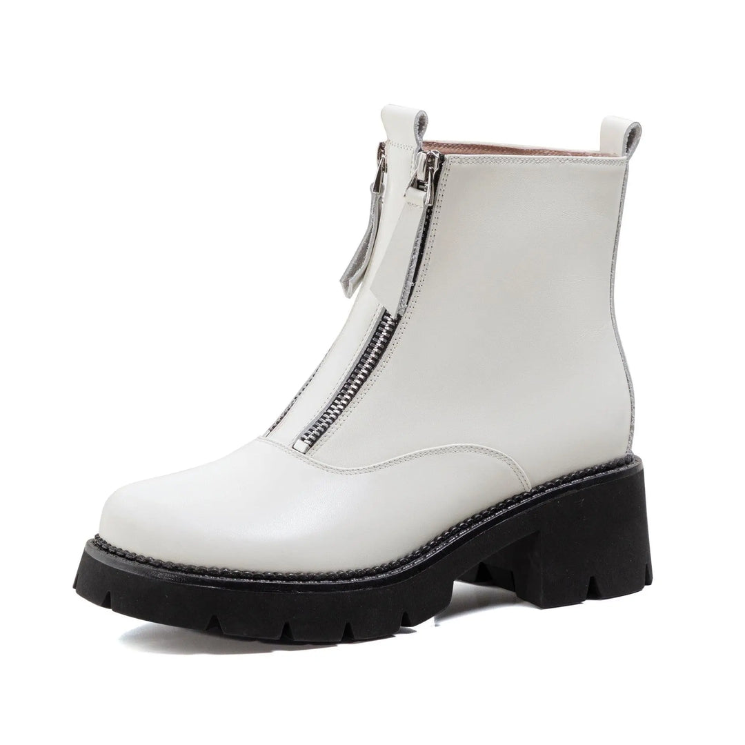 White leather ankle boots on a chunky black sole with side zipper