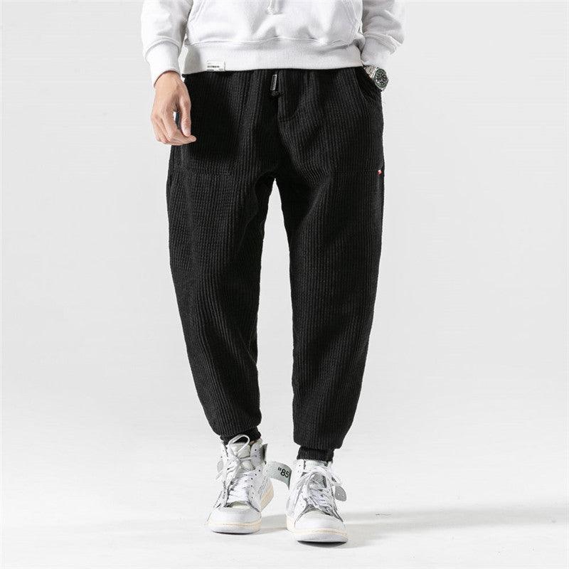 Men's black corduroy jogger pants with elastic waist and tapered ankle cuffs