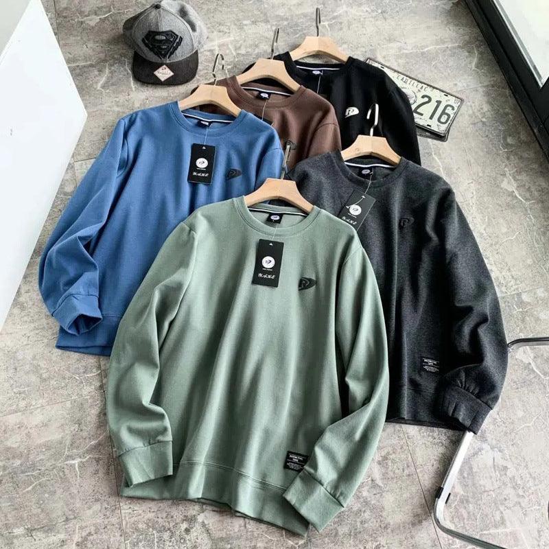 Long-sleeve pullover base shirts on hangers in blue, brown, green, and black; crew neck.