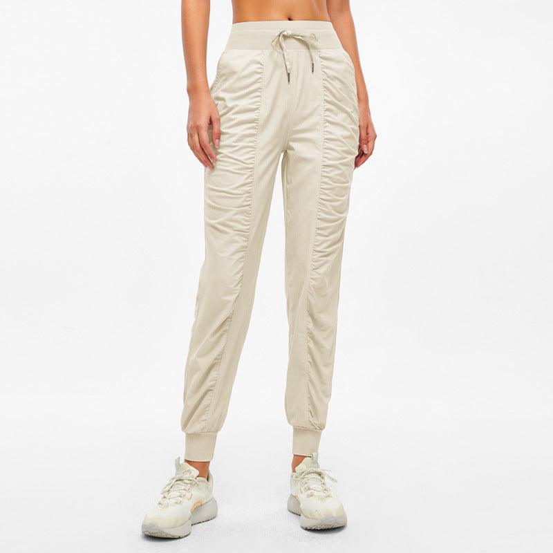 Light cream jogger pants with drawstring waistband and tapered ankle cuffs