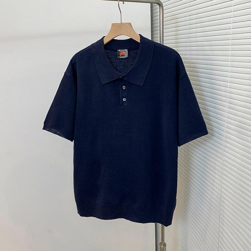 Navy short-sleeve polo shirt on hanger, fold-over collar with 3-button placket.