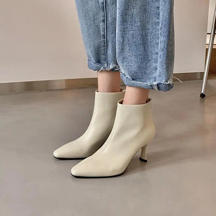 Milky white ankle boots with pointed toe and slim heel.