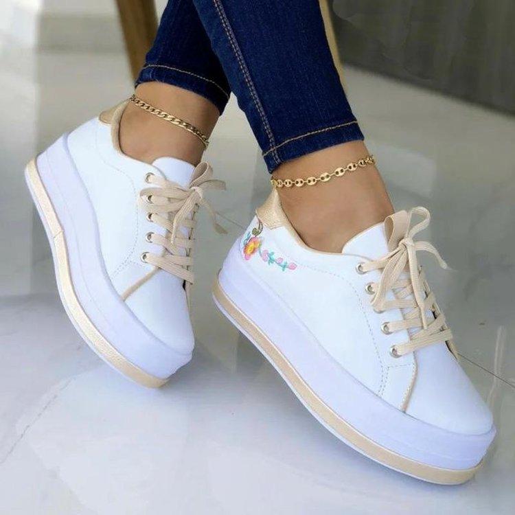 White lace-up sneakers with colorful flower embroidery on side, beige laces, gold chain anklet