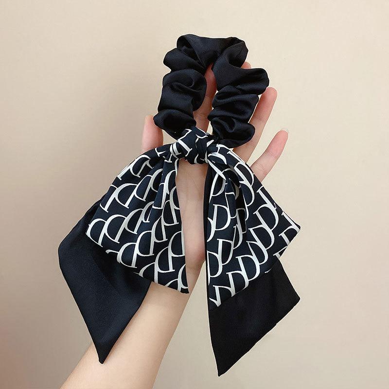 Satin hair headband with tied bow, black scarf with white motif and black scrunchie
