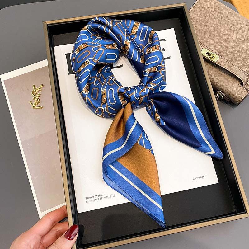 Blue and gold patterned silk scarf with striped border and tied drape.