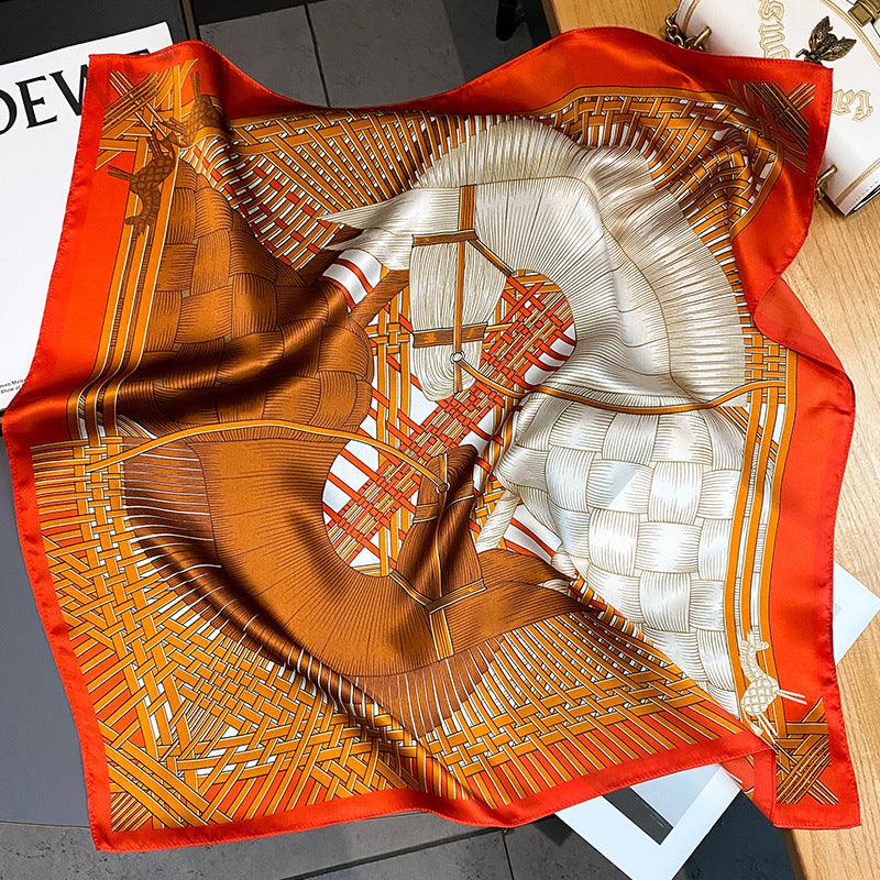 Orange and red silk scarf with woven pattern, white center, and decorative border.