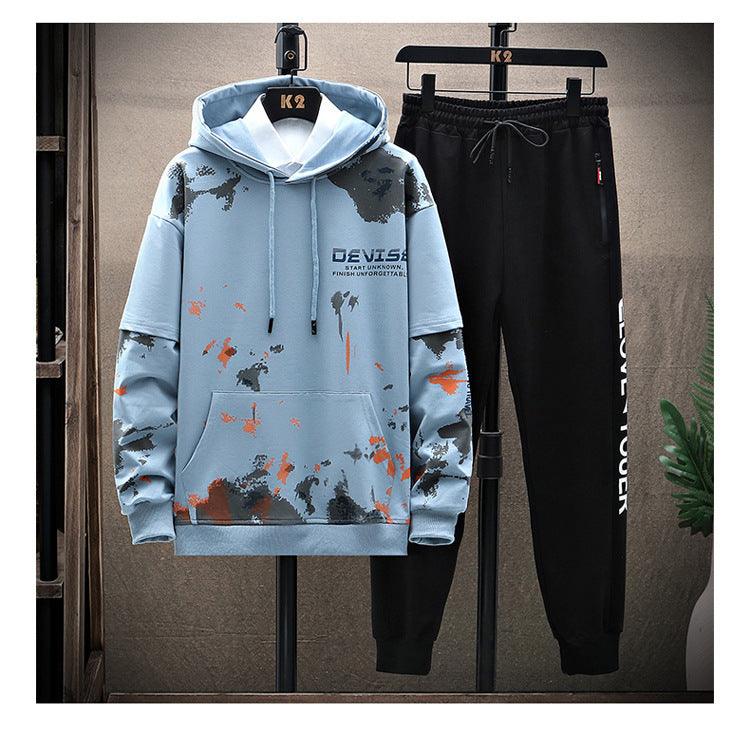 Light blue hooded sweatshirt with camo splatter print and black drawstring sweatpants