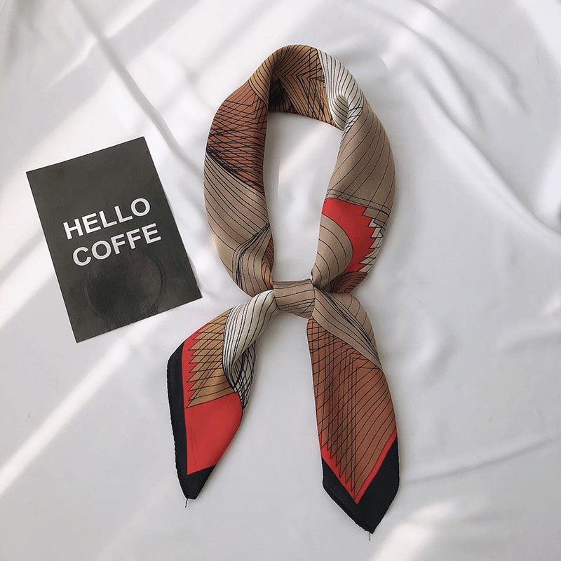 Printed scarf in beige and brown with red accents, tied center knot and pointed ends