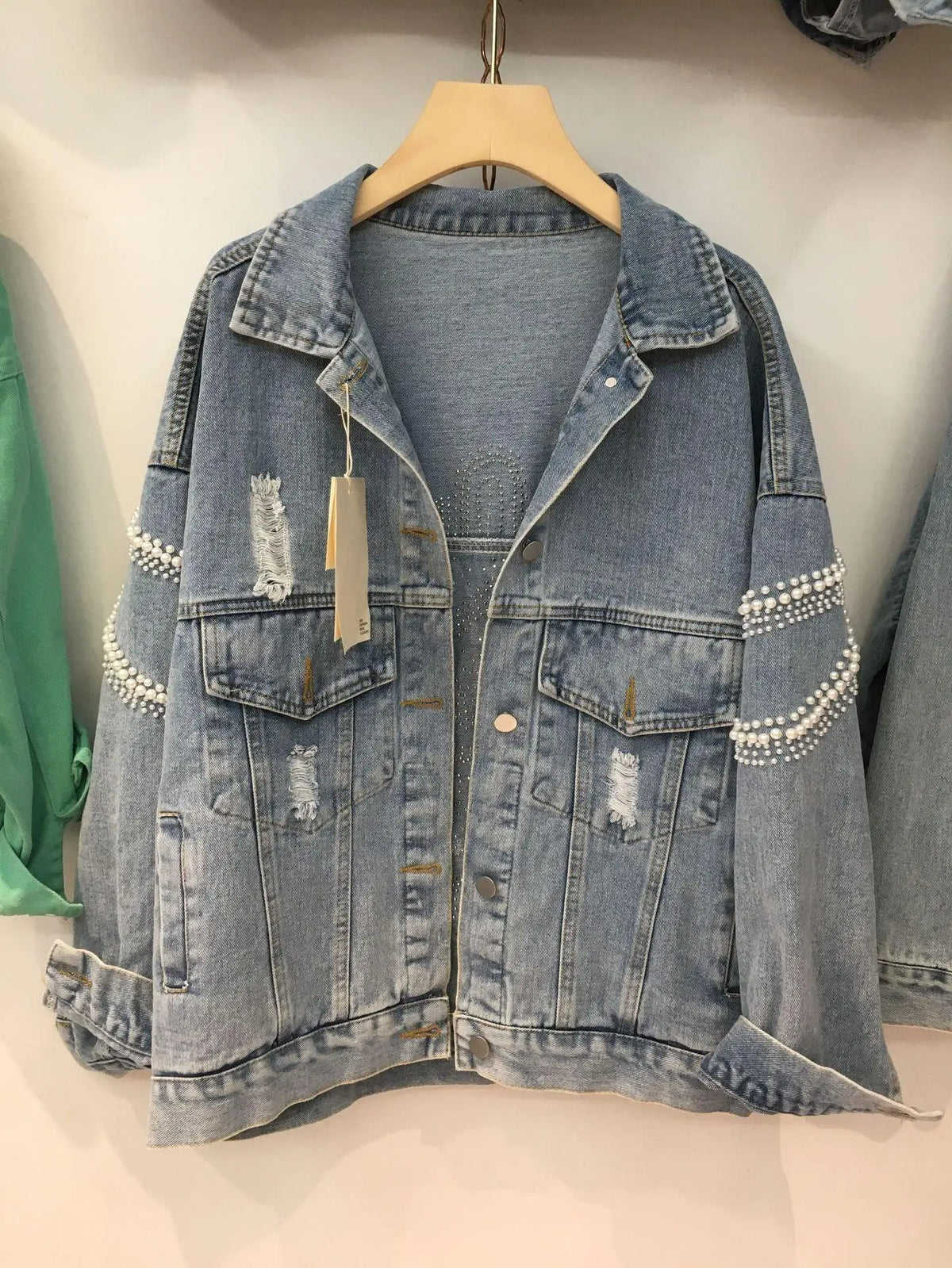 Light blue denim jacket with pearl bead embellishment on cuffs and pockets