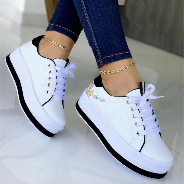 White lace-up sneakers with flower embroidery, black sole, white laces, bow at tongue