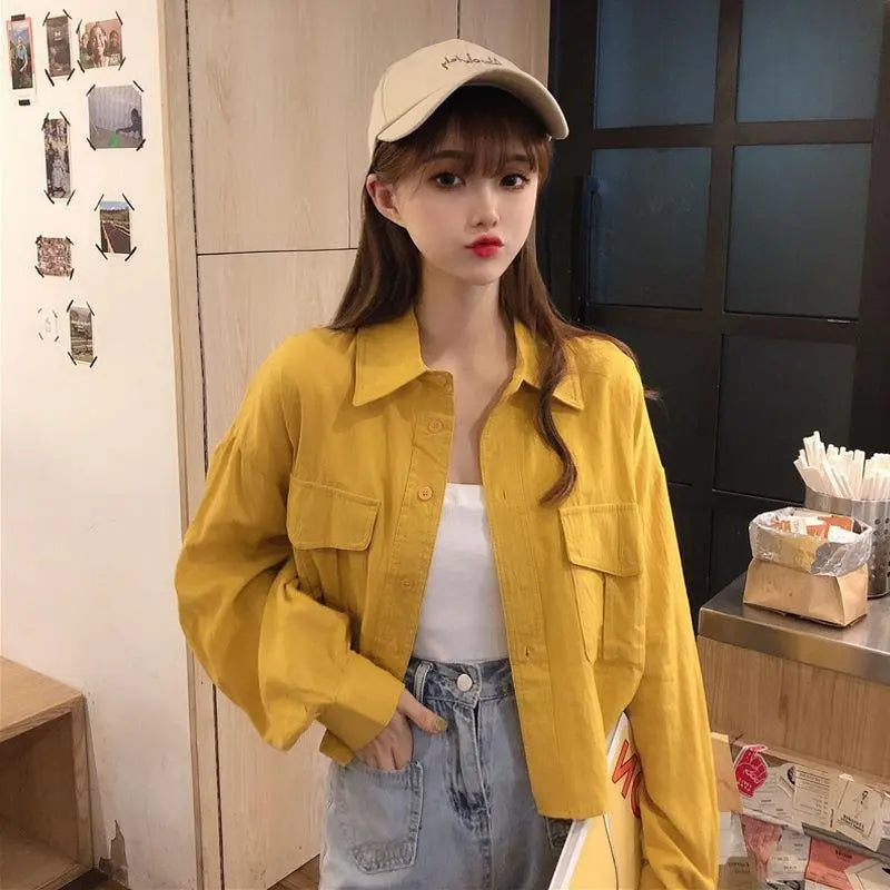 Loose yellow button-up long-sleeve shirt with chest pockets and point collar