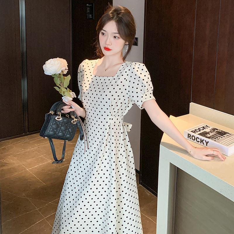 Beige polka-dot midi dress with square neckline, puff sleeves, and bow-tie waist detail