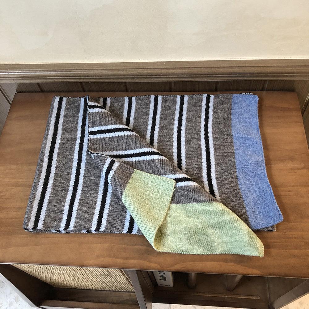 Knitted wool scarf folded; black, white, and gray stripes with blue and sage end